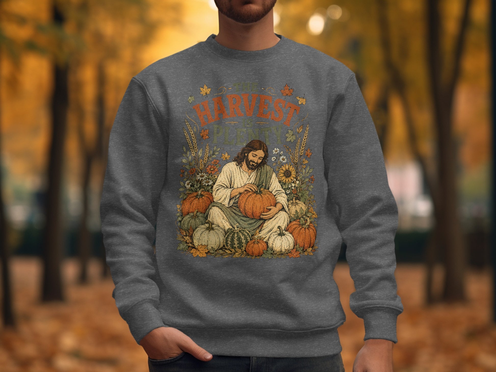 Jesus surrounded by pumpkins and autumn leaves on a gray sweatshirt.