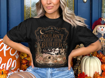 Black t-shirt with "Falloween Jesus Couldn't Keep Him Buried Ain't No Grave" text.