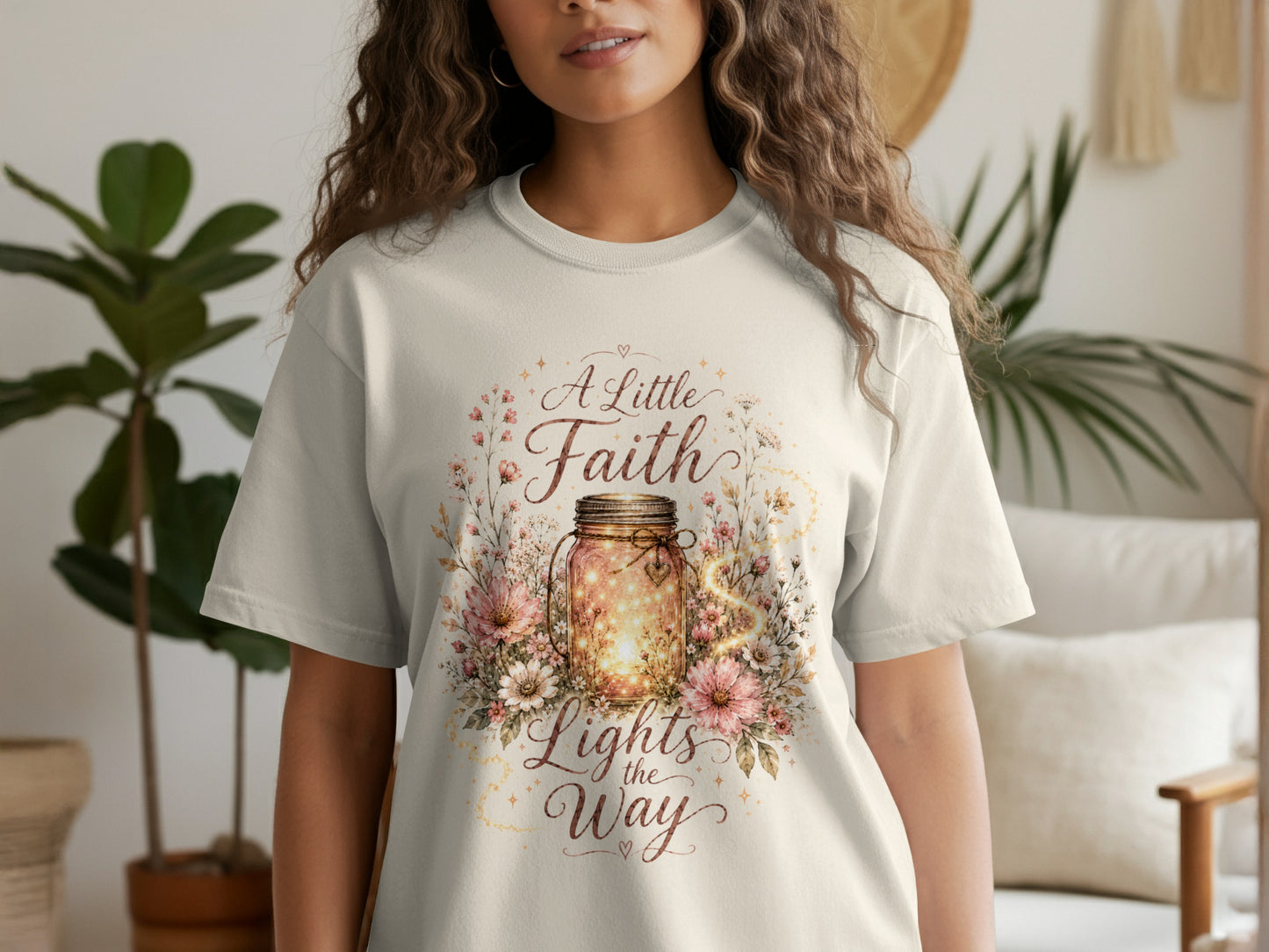 Cream t-shirt with "A Little Faith Lights the Way" text and a floral mason jar graphic.
