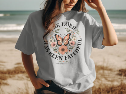 Light blue t-shirt with floral wreath, butterfly, and "The Lord Has Been Faithful" text.