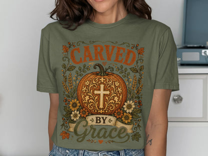 Olive green t-shirt with pumpkin, cross, and "Carved by Grace" text.