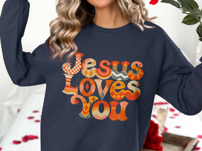 Navy sweatshirt with "Jesus Loves You" in colorful retro text.
