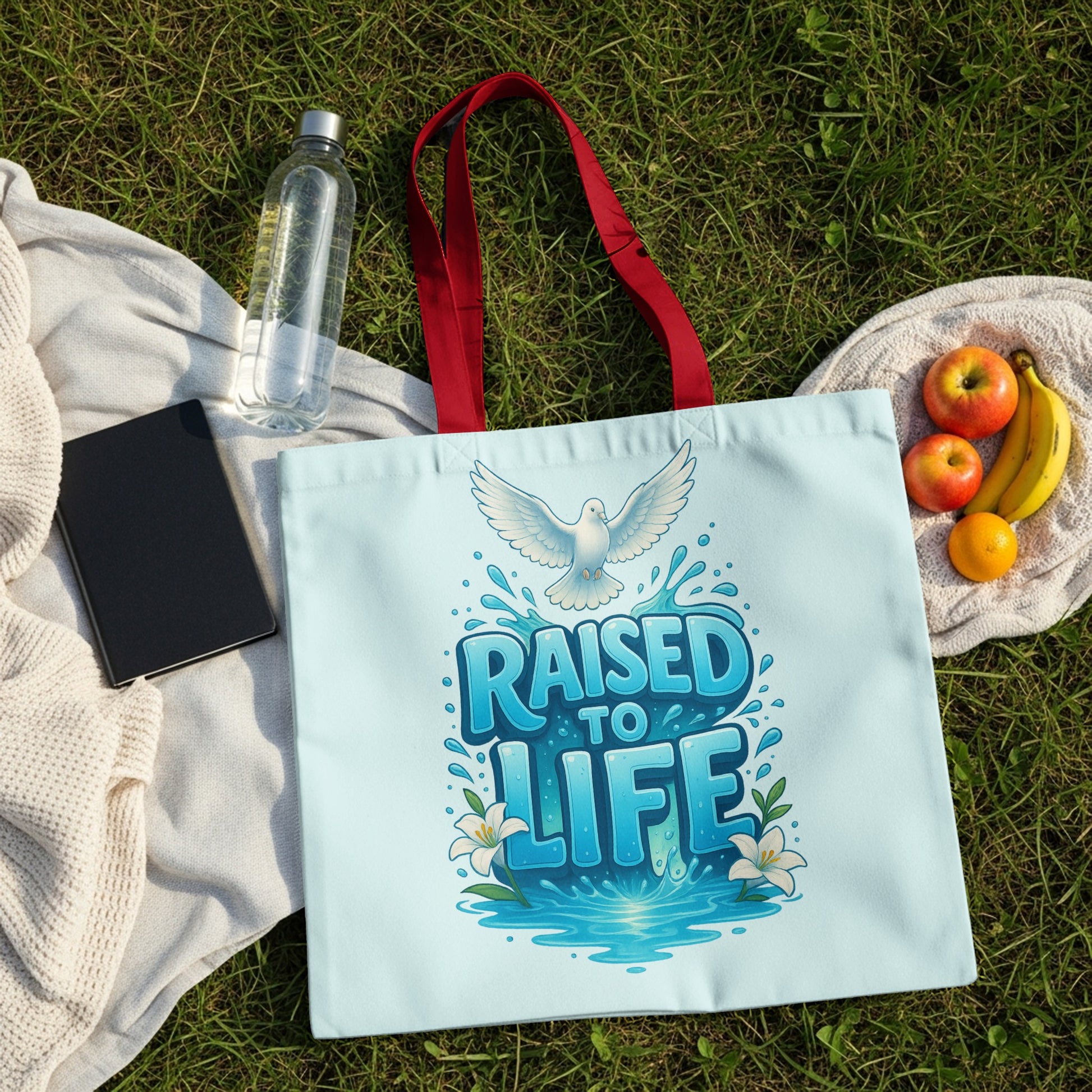Light blue tote bag with red handles featuring a dove and "RAISED TO LIFE" text.