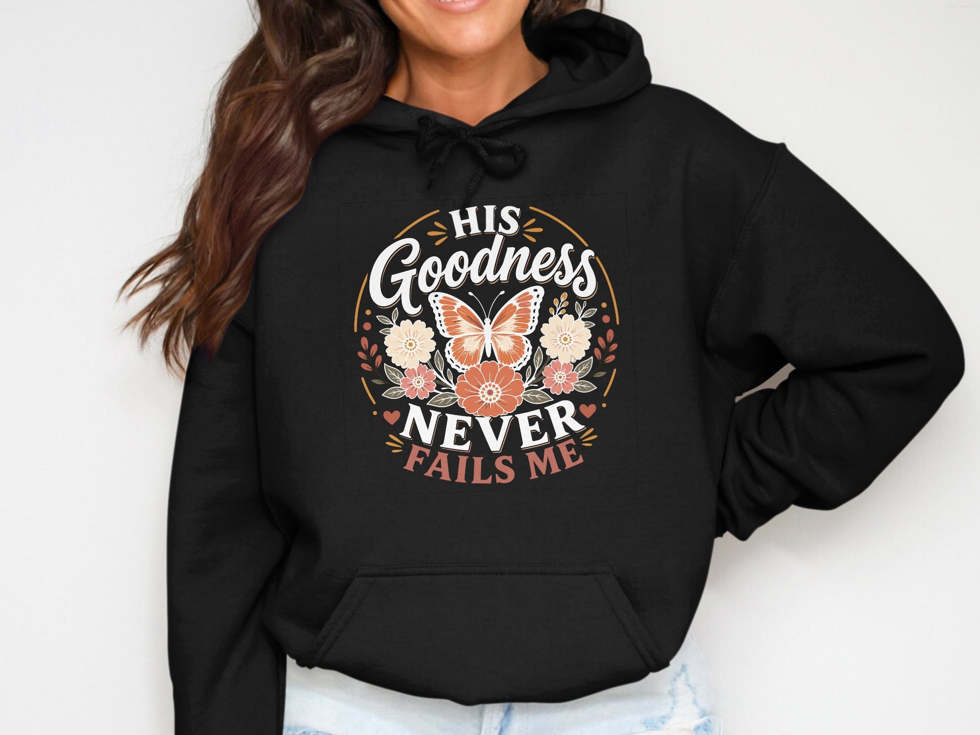 Black hoodie with floral and butterfly graphic and text "His Goodness Never Fails Me".