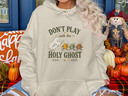 Cream hoodie with "Don't Play with the Holy Ghost" ghost graphic.