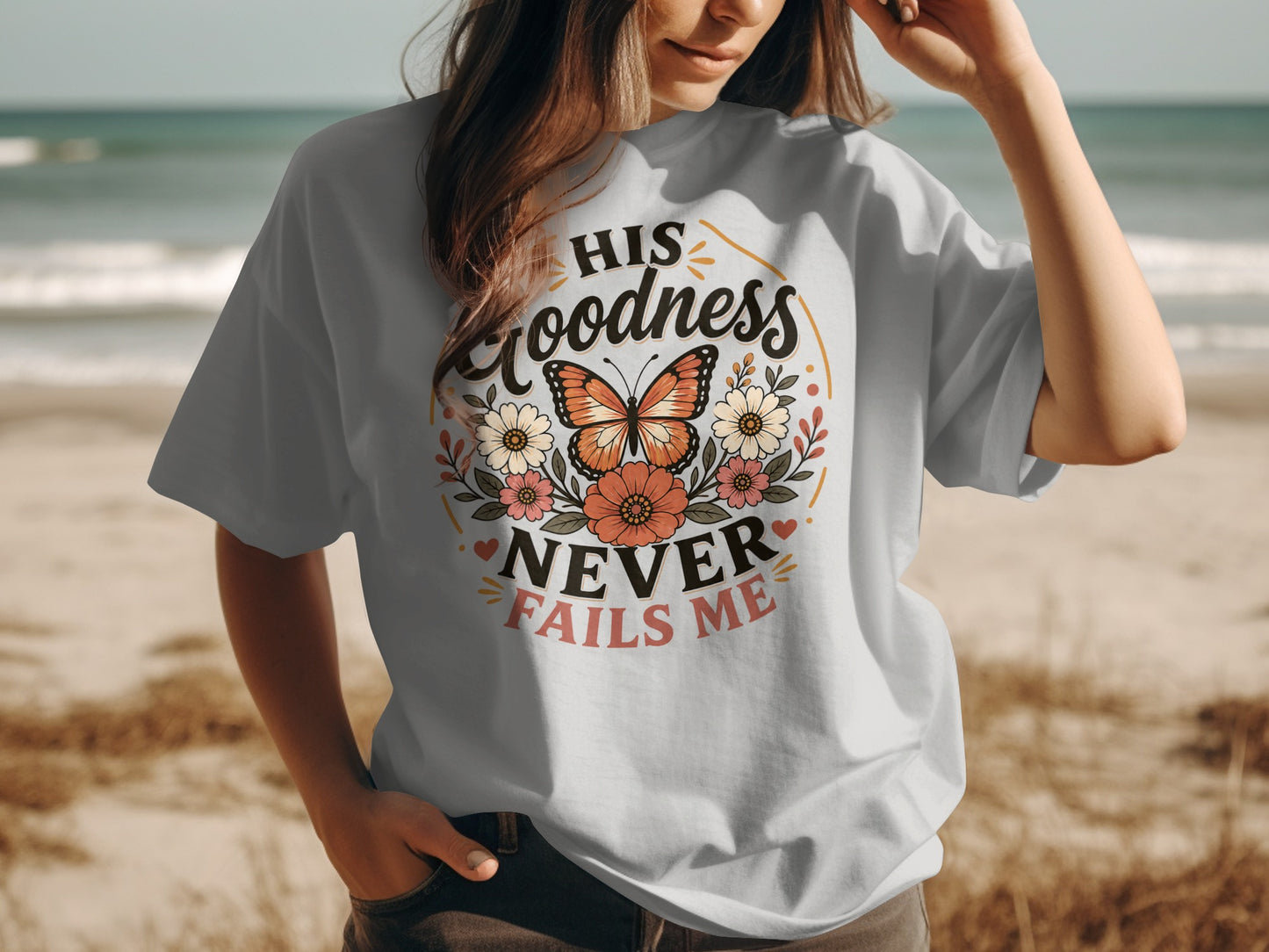 T-shirt with "His Goodness Never Fails Me" text and floral butterfly design.