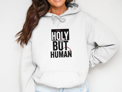 White hoodie with "Holy But Human" text and angelic/demonic graphics.