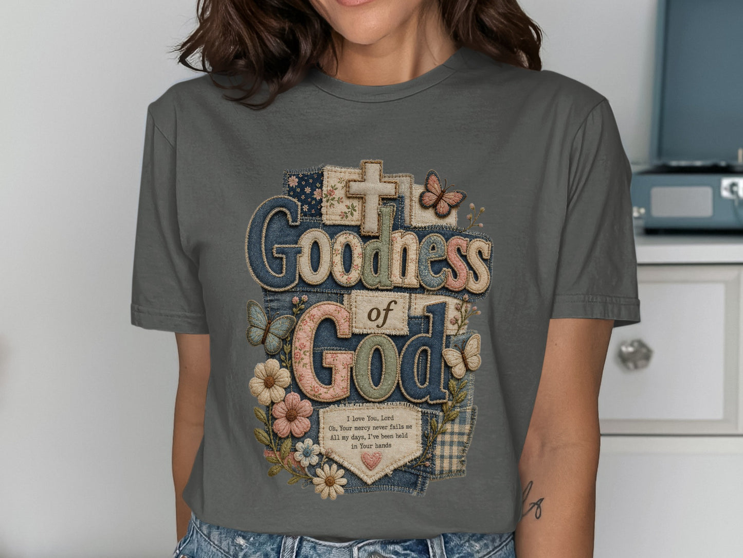 T-shirt with "Goodness of God" text, butterflies, and flowers design.
