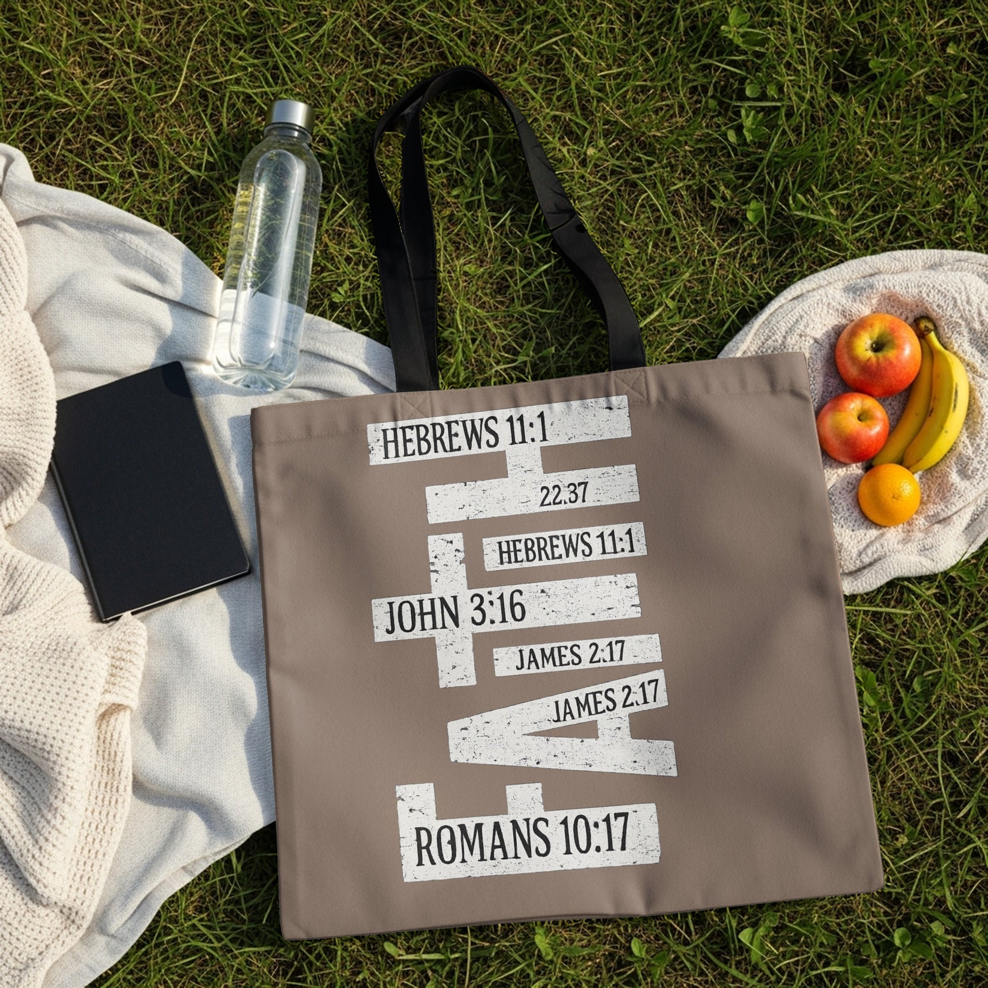 Taupe tote bag with scripture references printed in white distressed block letters.