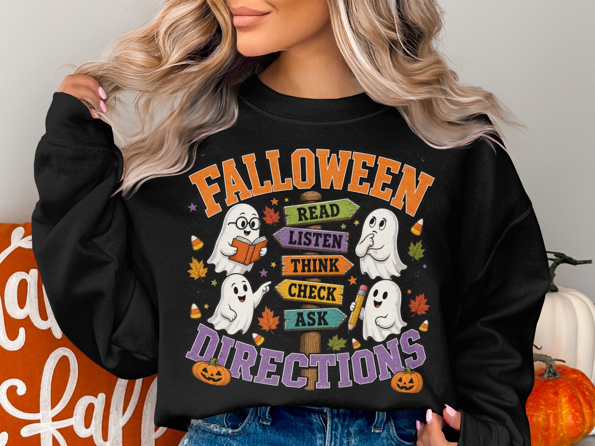 "Falloween" text with ghosts, directional signs, and pumpkins on a black sweatshirt.