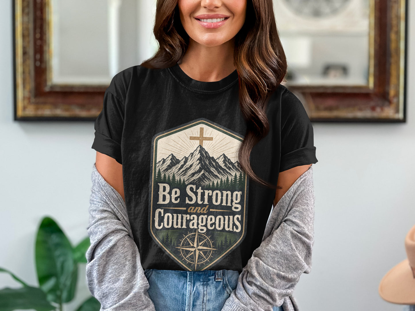 Black cotton t-shirt with mountains, compass, cross, and "Be Strong and Courageous" text.