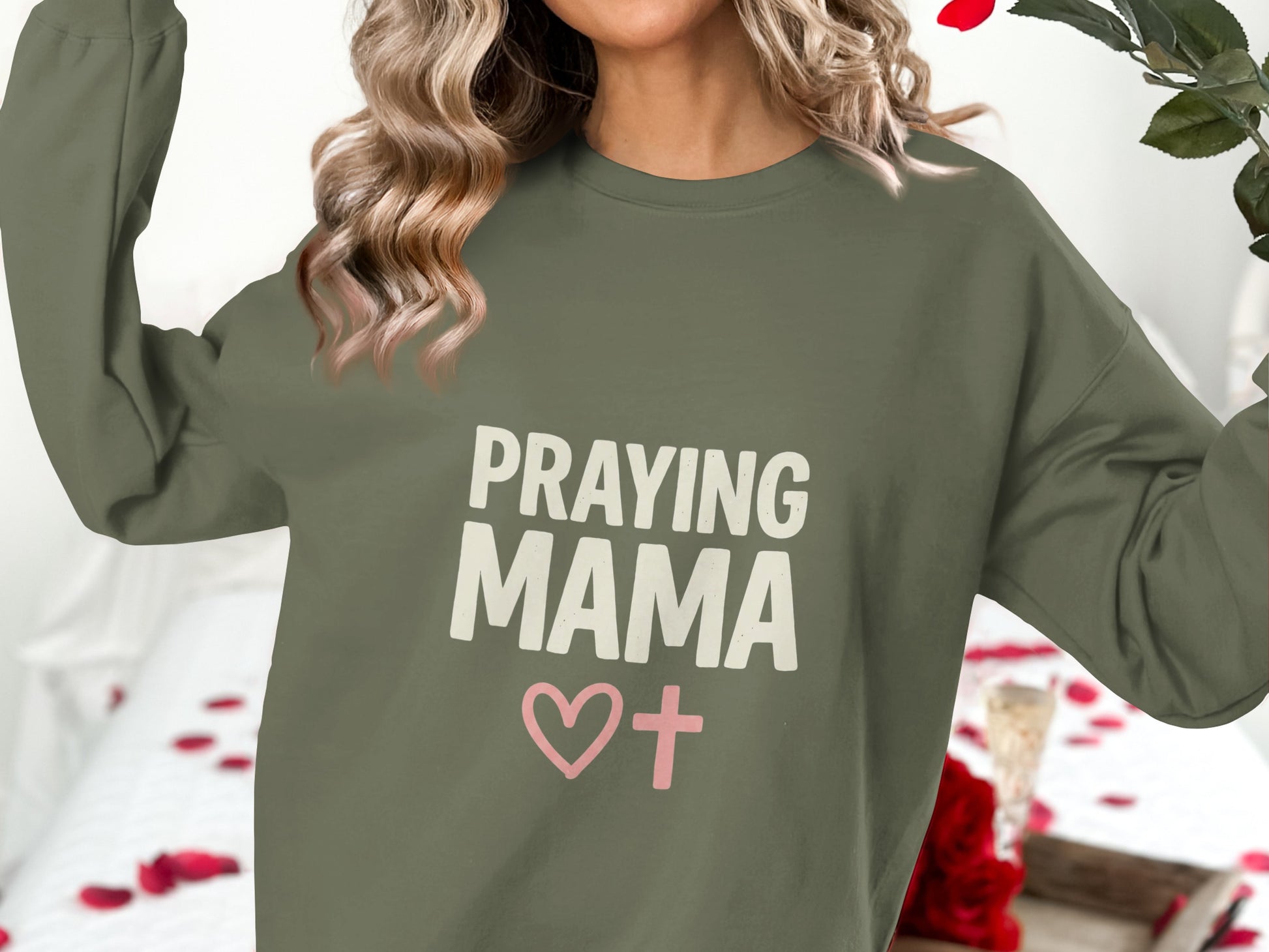 Olive green sweatshirt with "PRAYING MAMA" and a pink heart cross graphic.