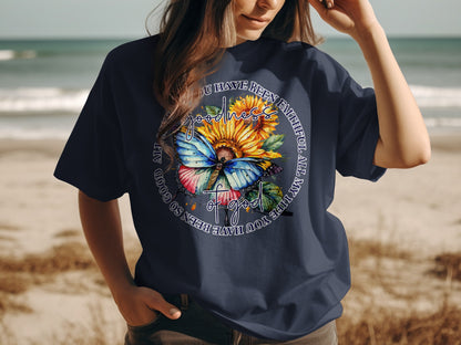 Navy t-shirt with sunflower, butterfly, and inspirational text "GOODNESS YOU HAVE BEEN FAITHFUL ALL MY LIFE SO GOOD".