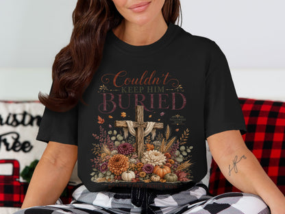 Black t-shirt with "Couldn't Keep Him Buried" graphic and a cross.