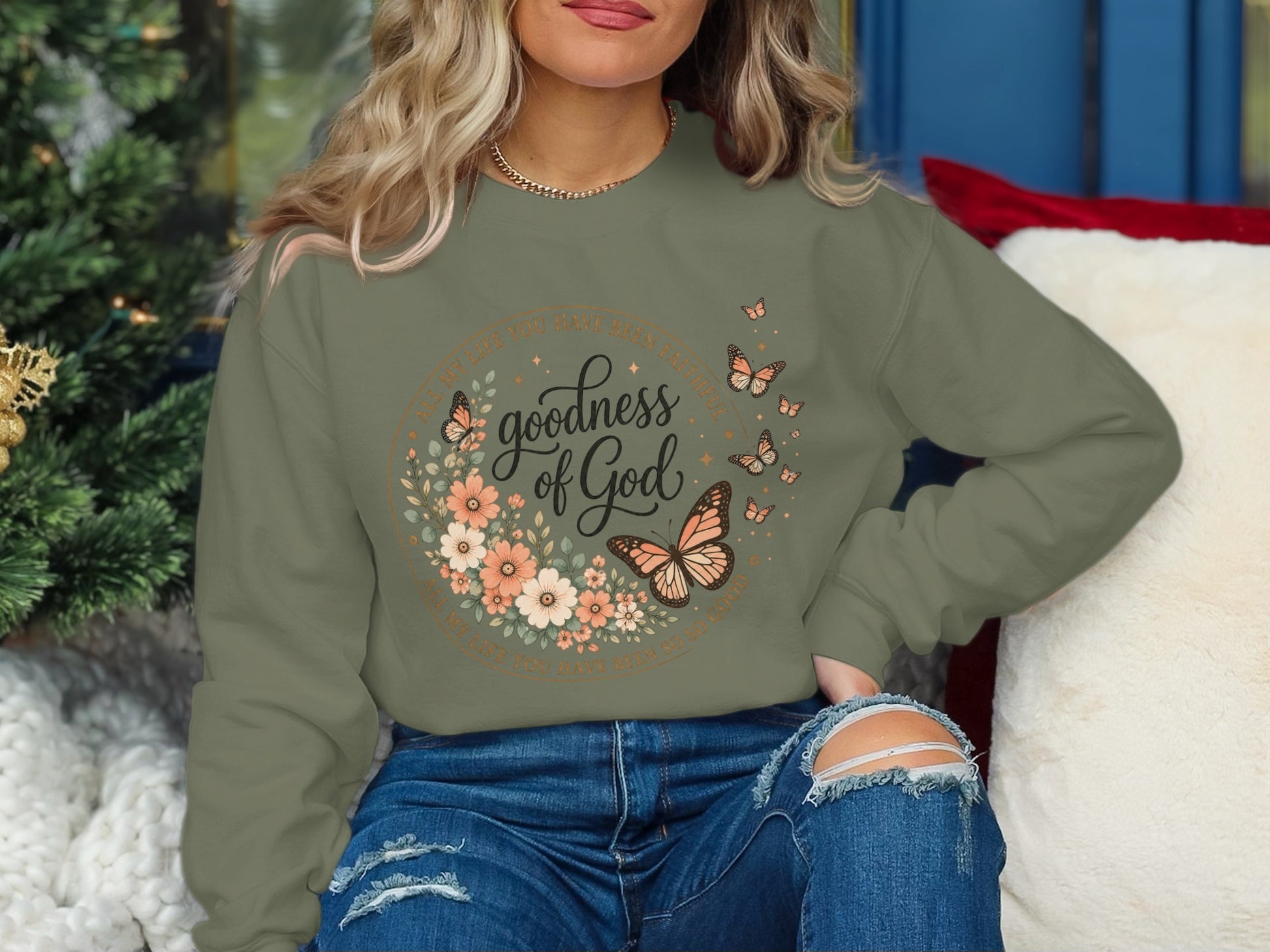 Green crewneck sweatshirt with "Goodness of God" floral design and butterflies.