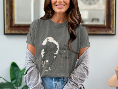 Grey t-shirt with a line drawing of a praying woman and text "She Believed She Could, So She Prayed."