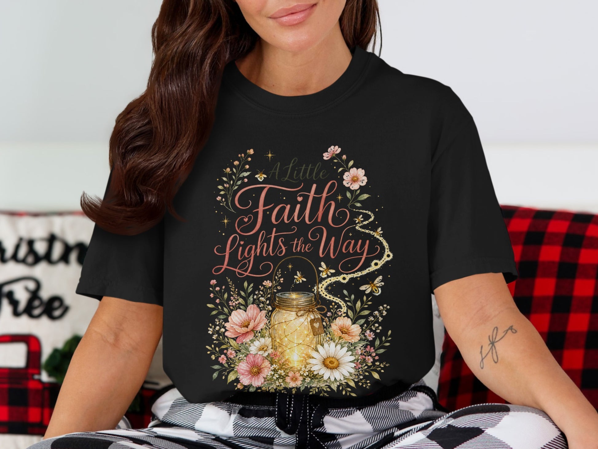 Black t-shirt with floral design and text "A Little Faith Lights the Way".