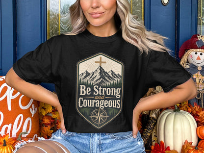 Black t-shirt with "Be Strong and Courageous" text, mountains, and compass design.