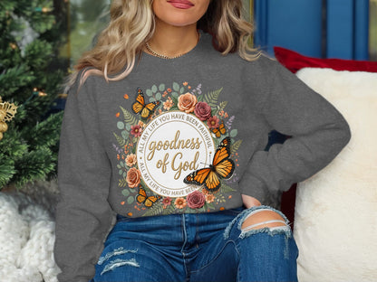 Gray sweatshirt with floral wreath, butterflies, and "Goodness of God" text.