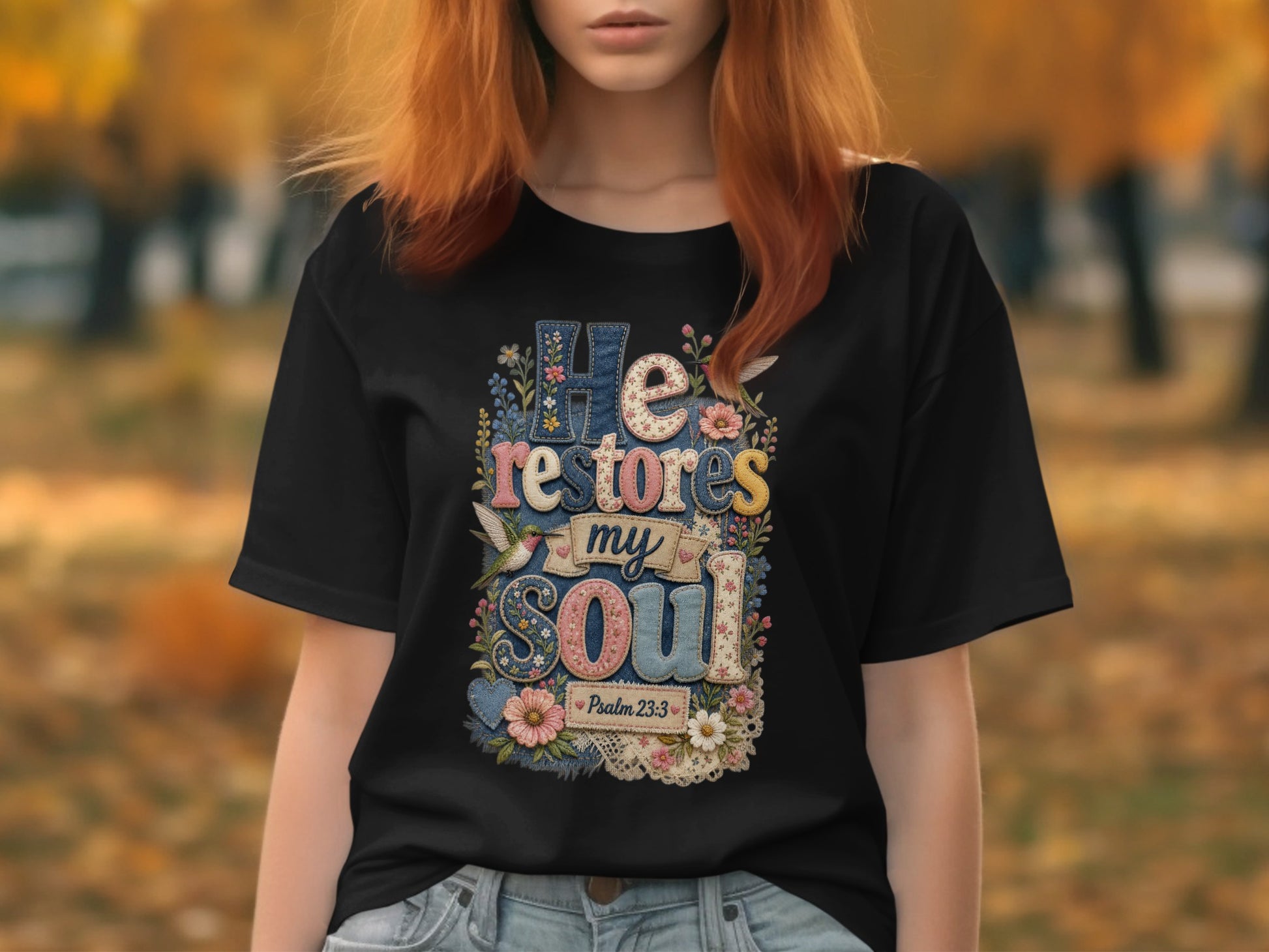 Black t-shirt with "He restores my soul" text and floral accents, Psalm 23:3.