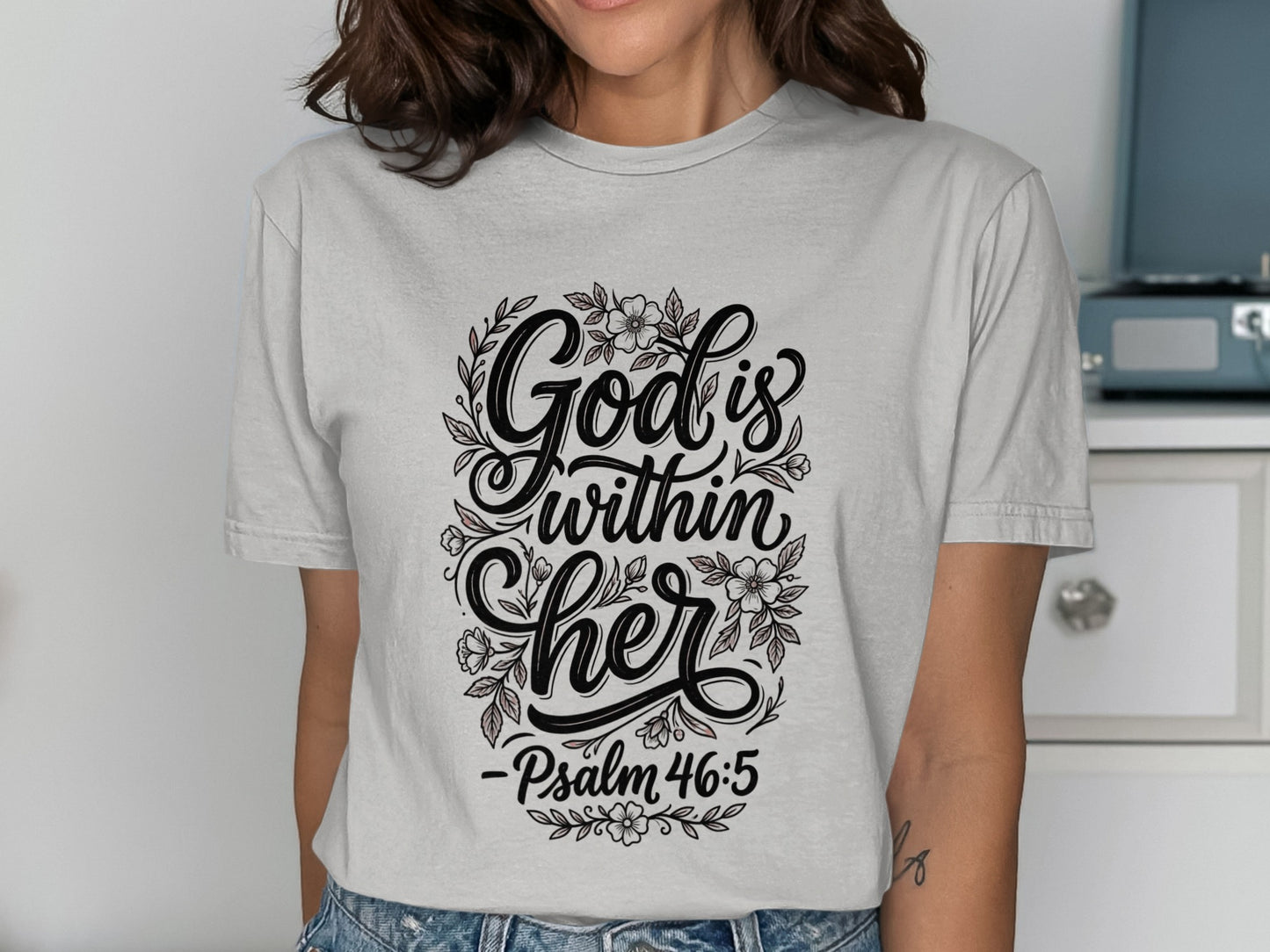 Gray t-shirt with "God is within her" and Psalm 46:5 in floral design.