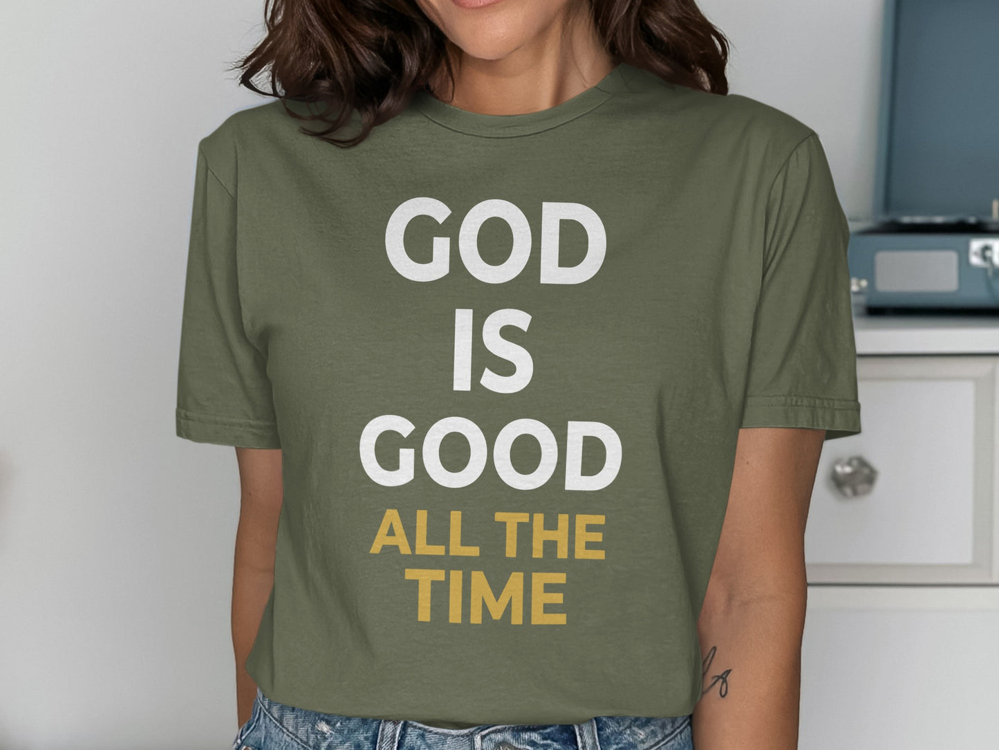 Green t-shirt with white and yellow text: "GOD IS GOOD ALL THE TIME"
