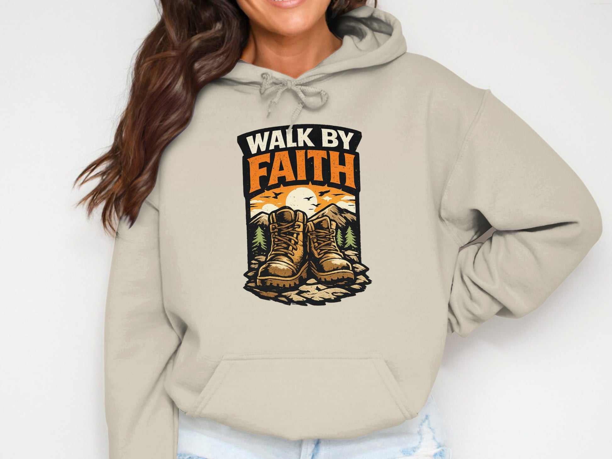 Beige hoodie with "Walk by Faith" text and hiking boots illustration.