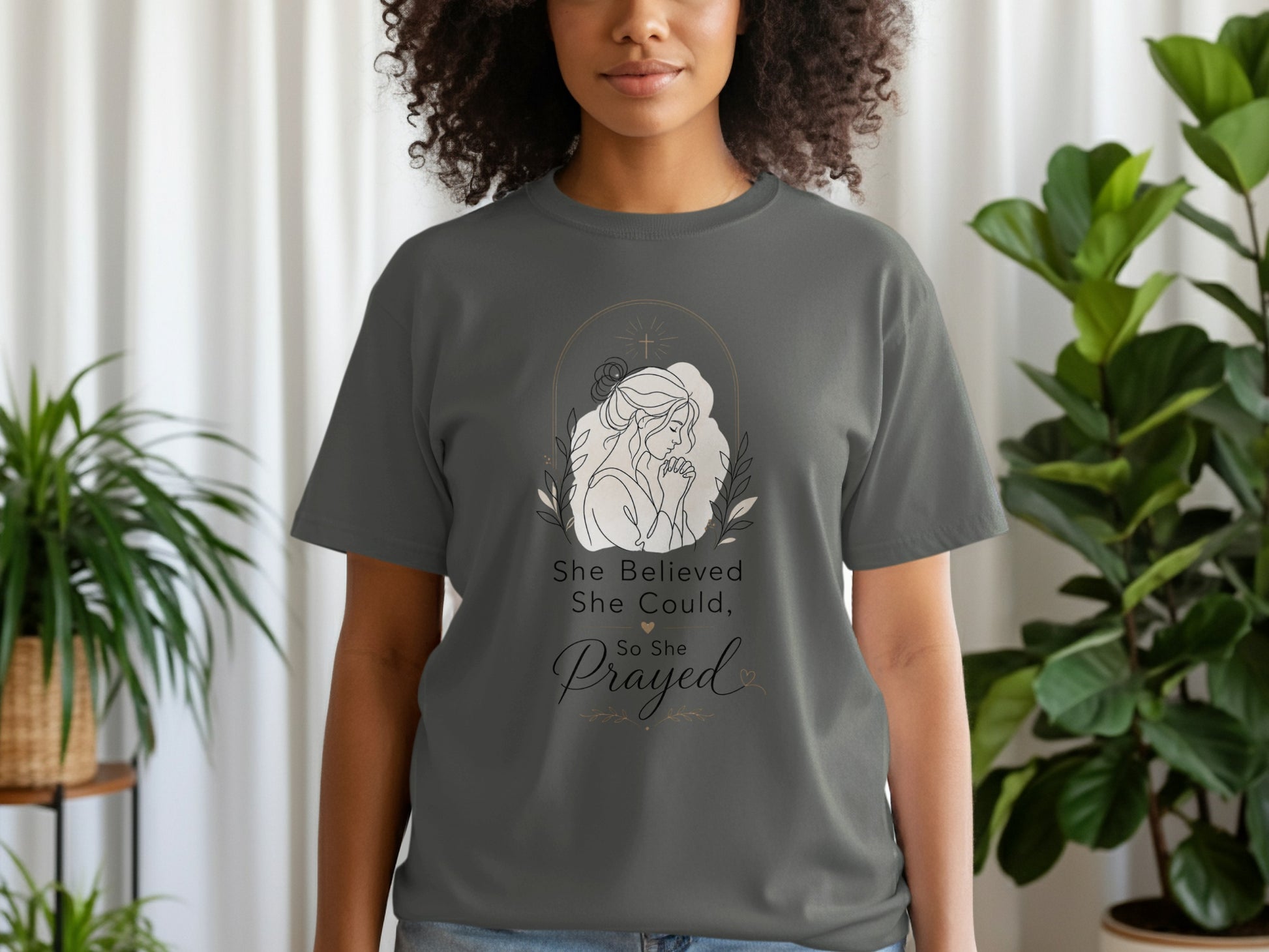 Dark grey t-shirt with "She Believed She Could, So She Prayed" text and praying woman graphic.