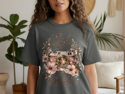 Gray t-shirt with a vintage camera surrounded by flowers and text "God Makes the World Beautiful."