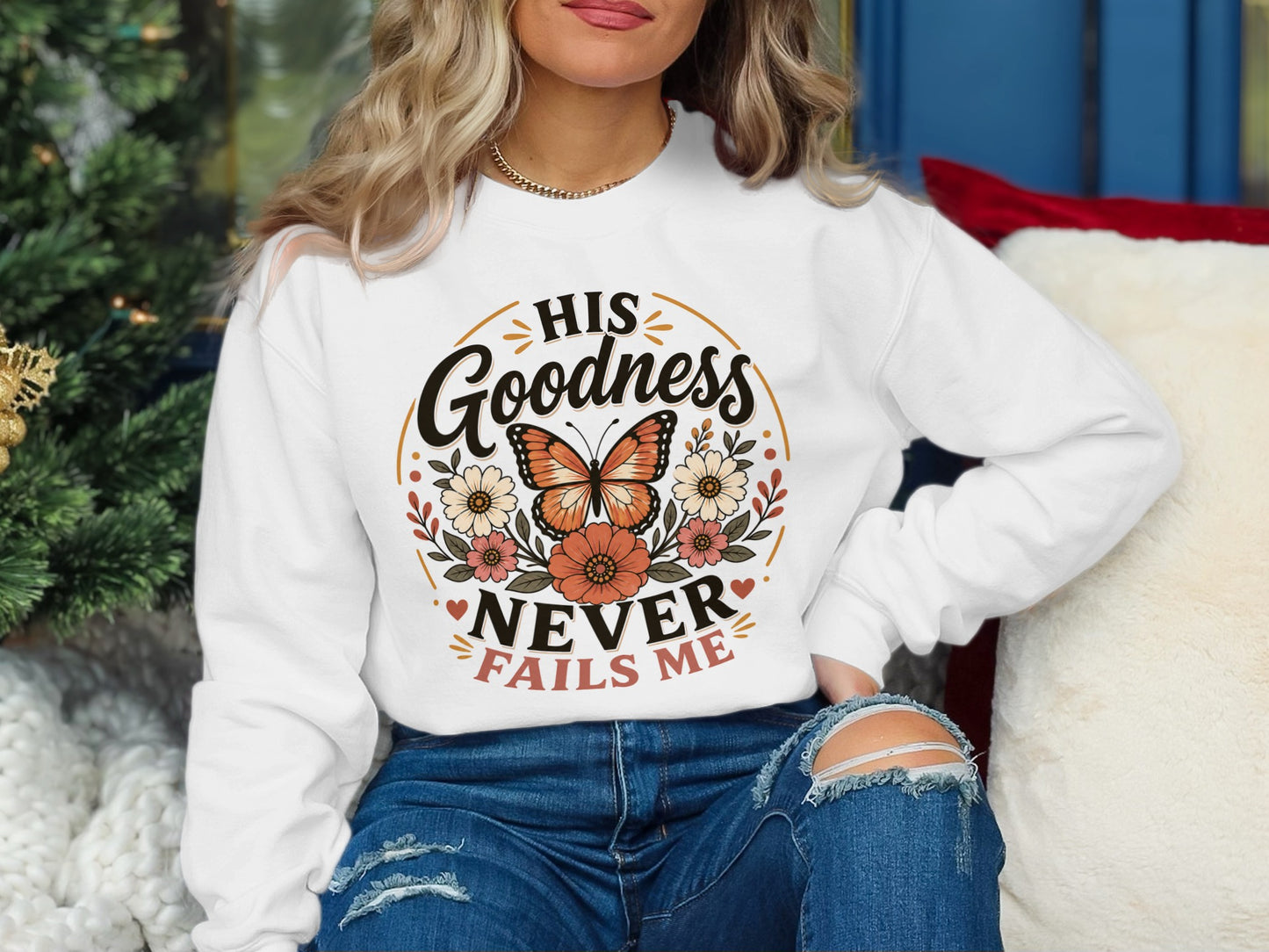 White sweatshirt with "His Goodness Never Fails Me" and butterfly design.