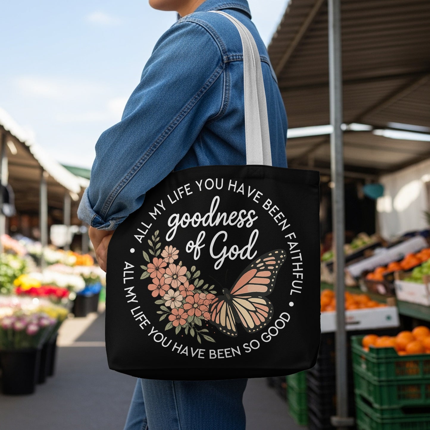 Black tote bag with "goodness of God" and floral butterfly design.