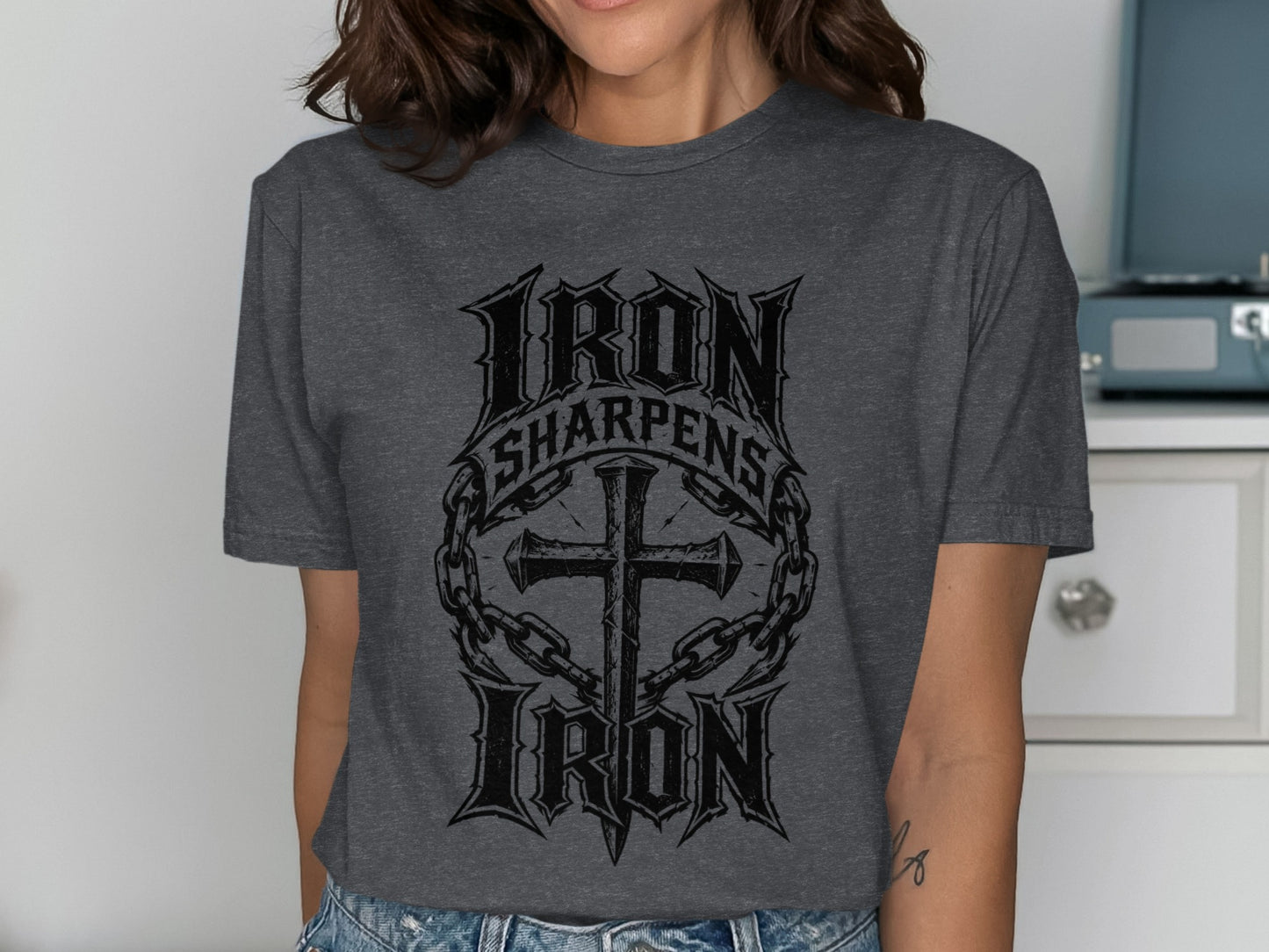 Dark grey t-shirt with "Iron Sharpens Iron" text and cross graphic.