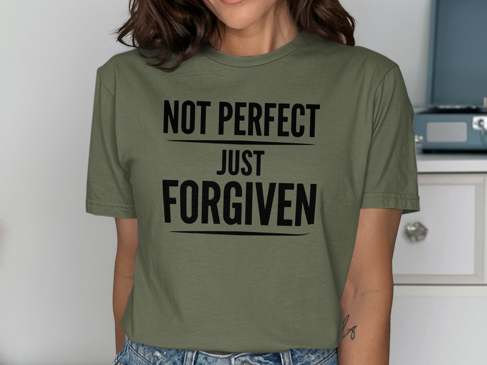 Green t-shirt with black text reading "NOT PERFECT JUST FORGIVEN".