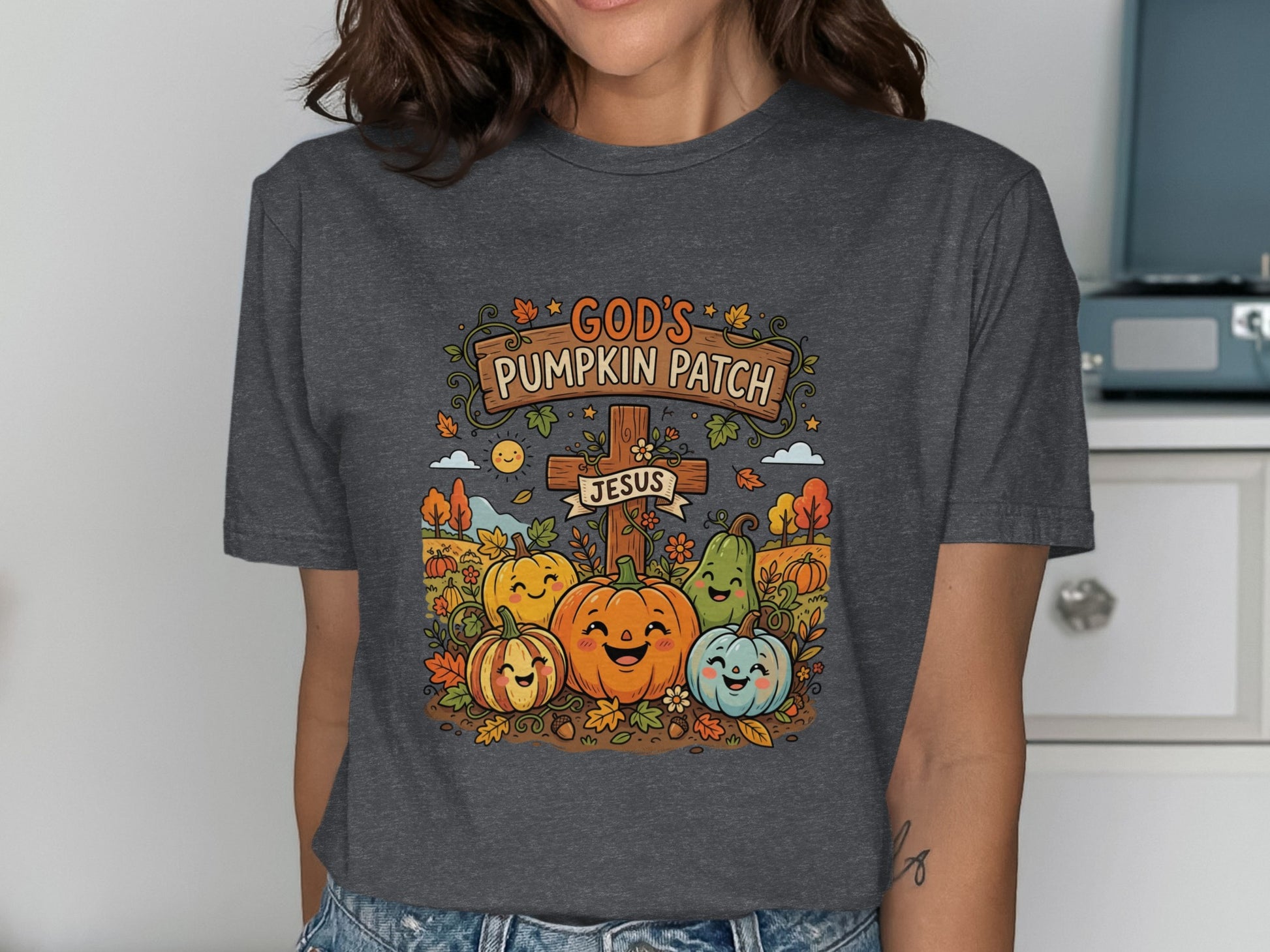 Graphic t-shirt with smiling pumpkins, cross, and "God's Pumpkin Patch Jesus" text.