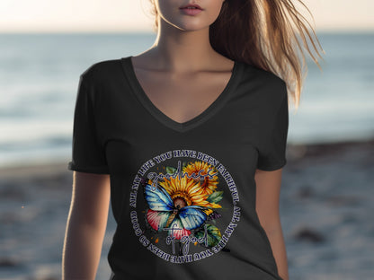 Woman wearing a black v-neck t-shirt with a circular graphic of sunflowers and a butterfly.