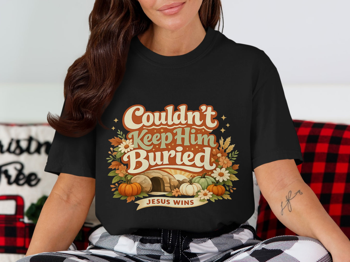 Black t-shirt with "Couldn't Keep Him Buried" and "Jesus Wins" text, tomb, and pumpkins.