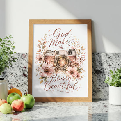 Framed artwork with a vintage camera and flowers, reads "God Makes the Blurry Beautiful."
