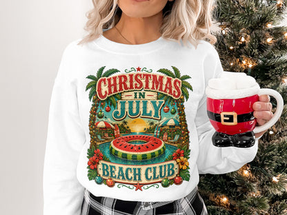 Woman in white sweatshirt with "Christmas in July Beach Club" graphic and Santa mug.