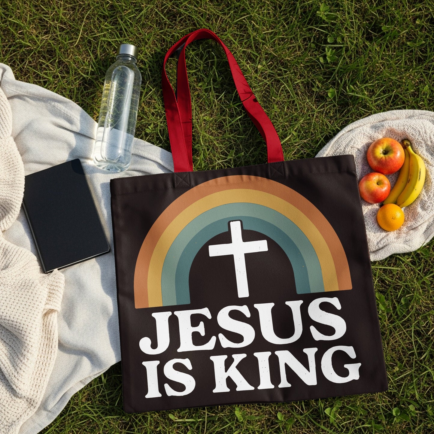 Black tote bag with rainbow and "Jesus is King" text.