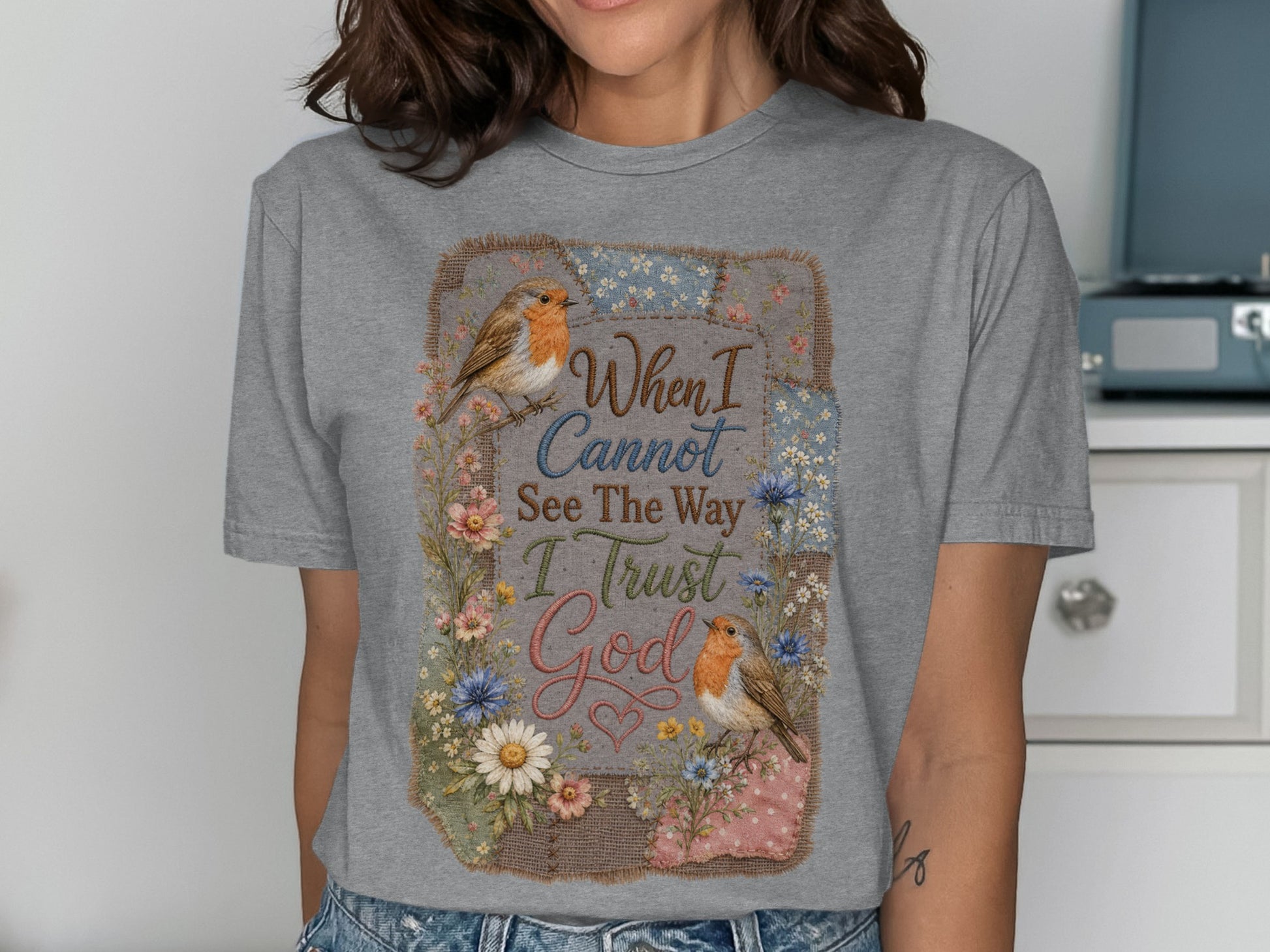 Gray t-shirt with floral border and birds, text reads "When I Cannot See The Way I Trust God".