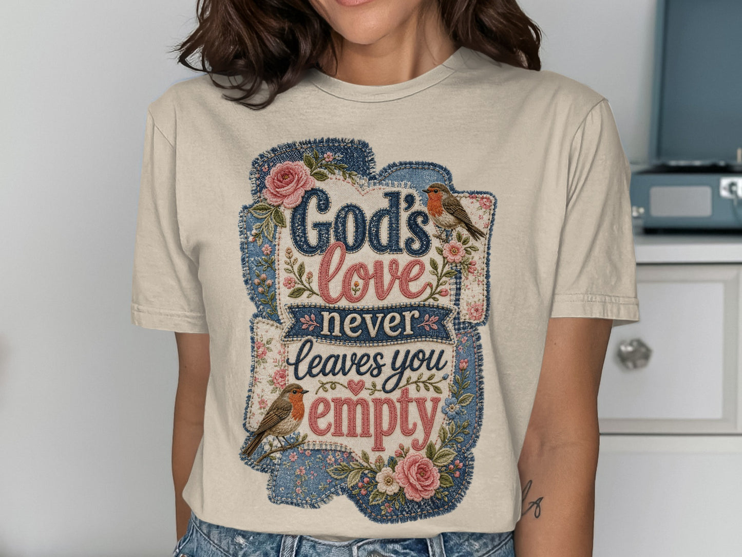 T-shirt with "God's love never leaves you empty" in floral and denim patches.