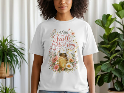 White t-shirt with a floral design featuring a lit mason jar and text "A Little Faith Lights the Way".