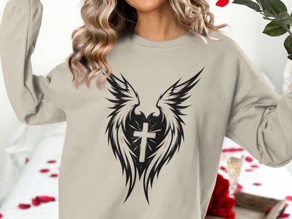 Crewneck sweatshirt with a winged cross graphic on a neutral background.