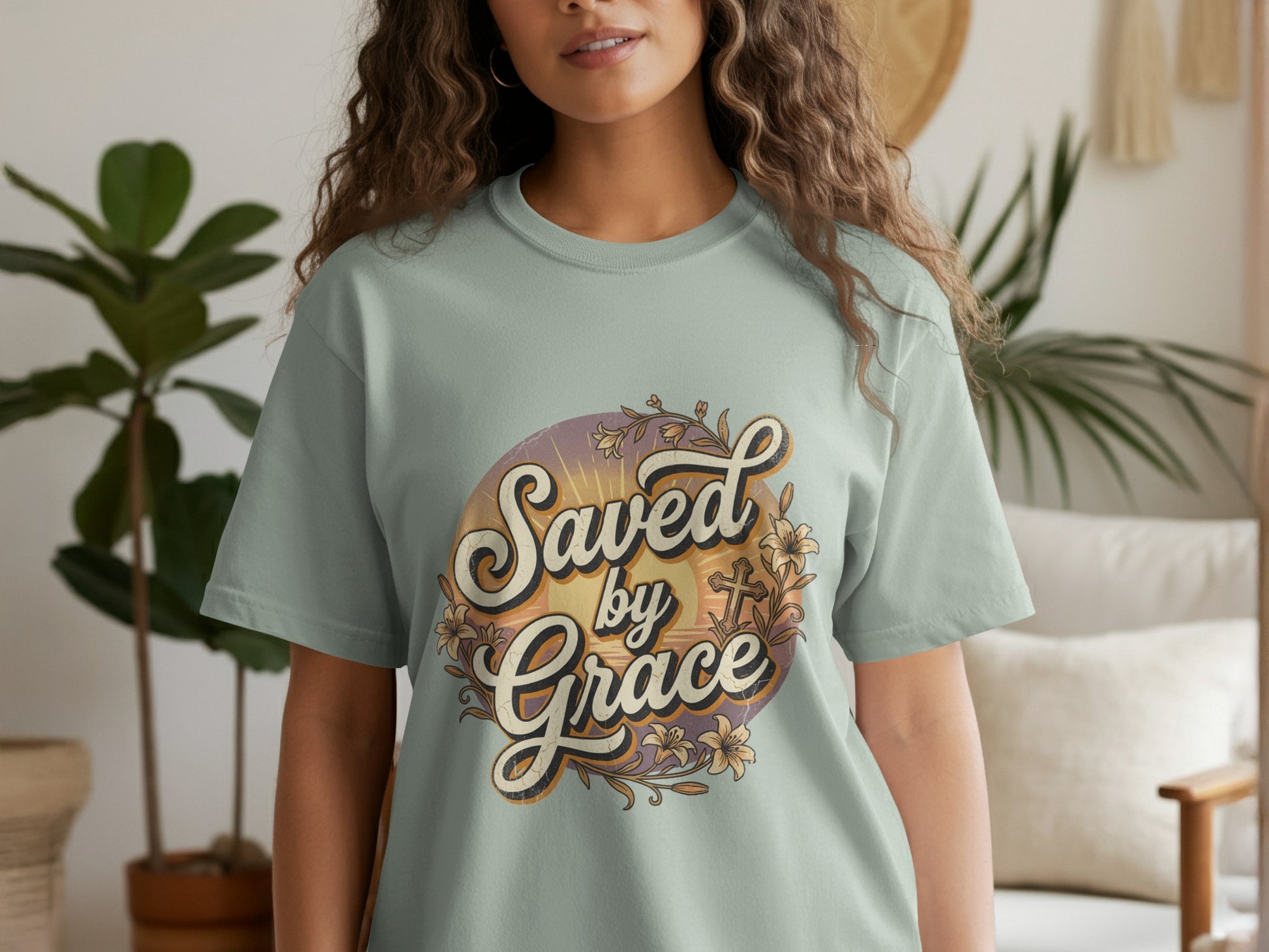 Light teal t-shirt with "Saved by Grace" text and floral cross design.