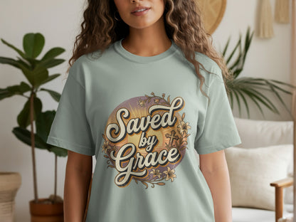 Light teal t-shirt with "Saved by Grace" text and floral cross design.