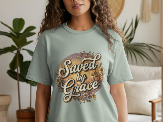 Light teal t-shirt with "Saved by Grace" text and floral cross design.