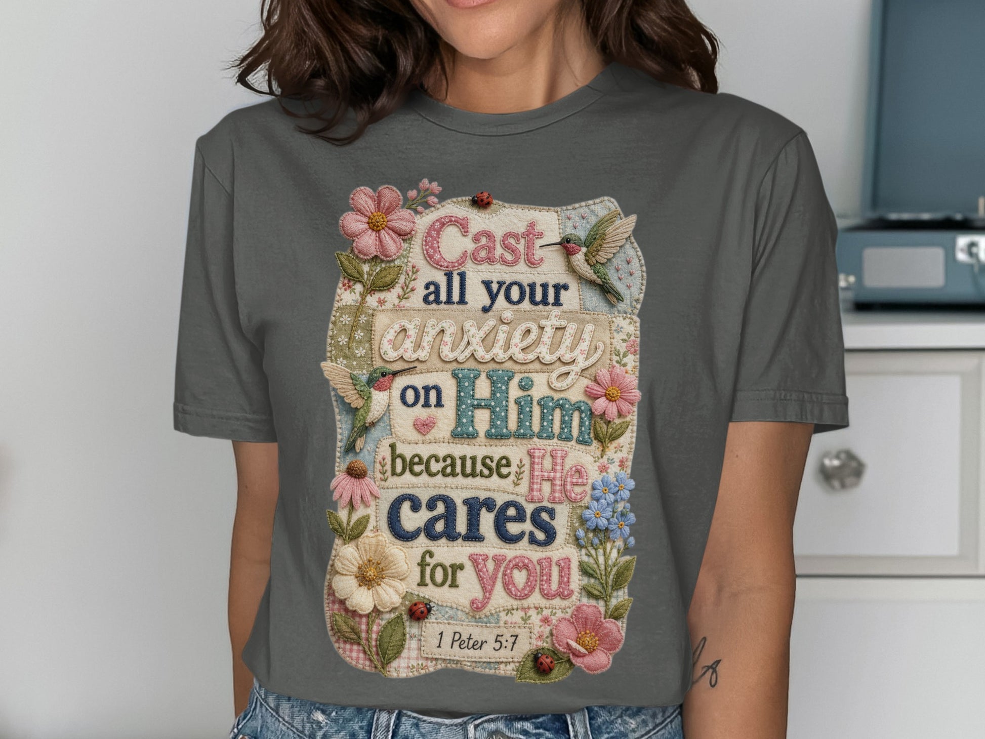 Gray t-shirt with floral design and Bible verse "Cast all your anxiety on Him because He cares for you 1 Peter 5:7."