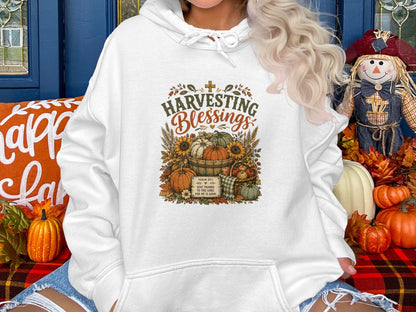 Hoodie with graphic "Harvesting Blessings," Psalm 107:1 text, pumpkins, sunflowers, and basket.