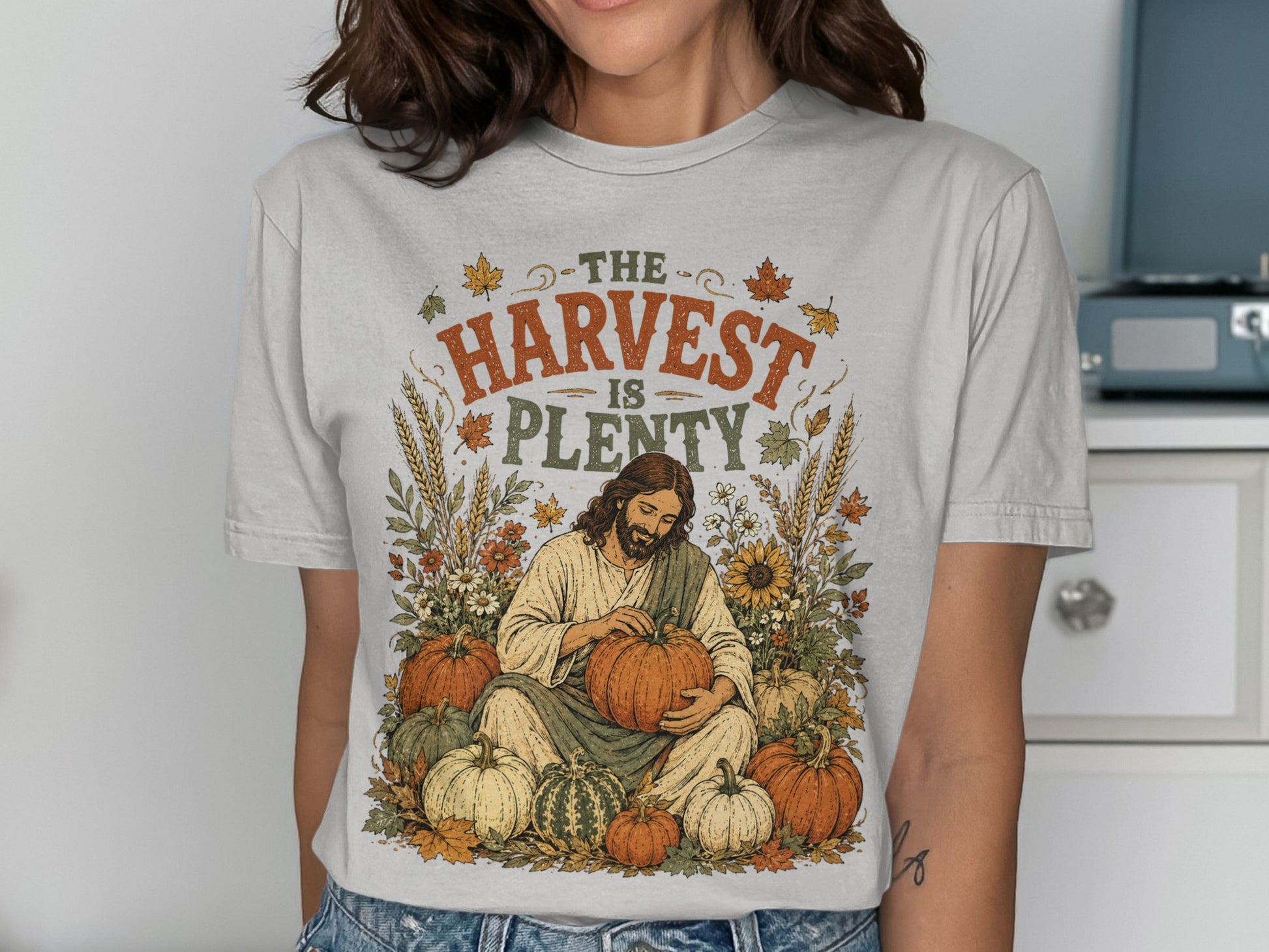 T-shirt with Jesus holding a pumpkin surrounded by harvest elements.