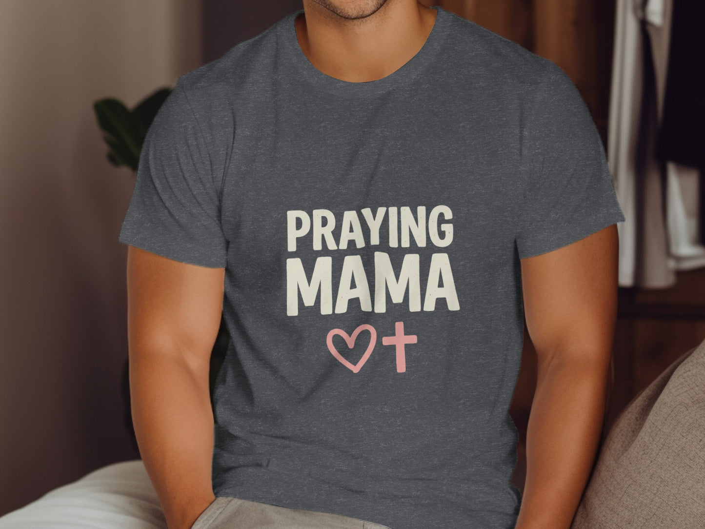 Dark grey t-shirt with "PRAYING MAMA" and pink heart with cross graphic.